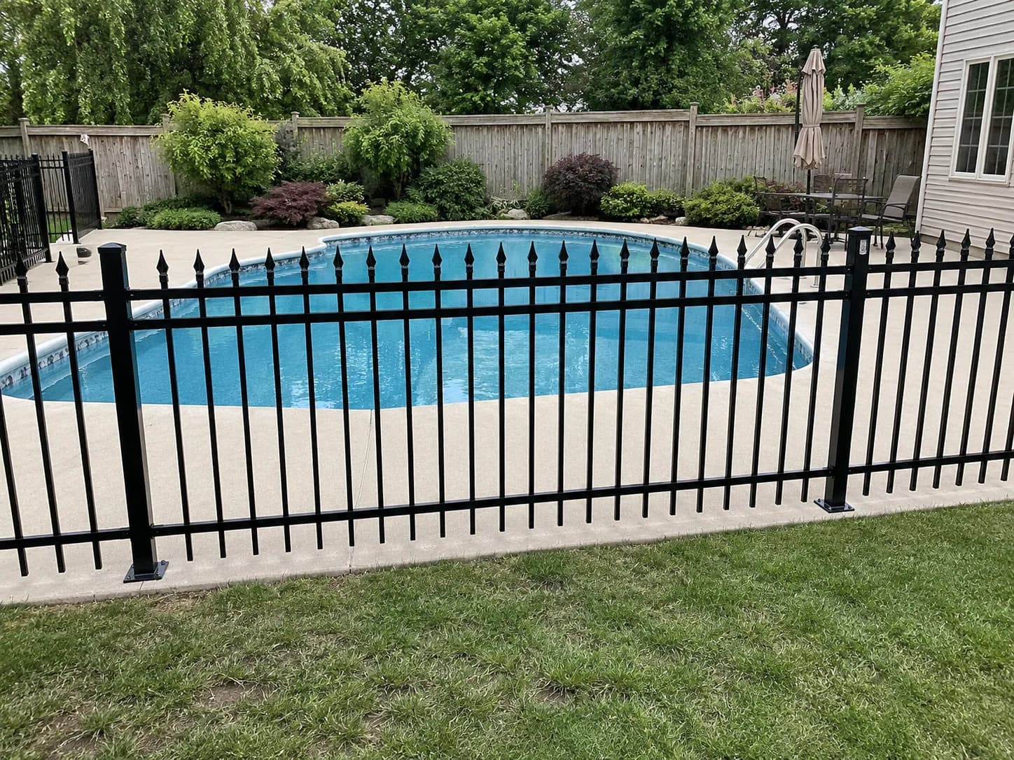 Black spear-top fence defining the edge of a residential property